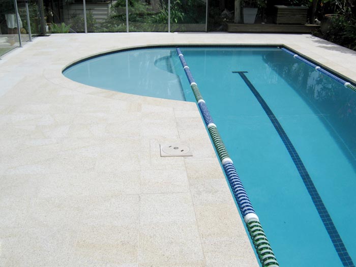 Almond Granite stone tile or pool paver shown in situ with matching coping