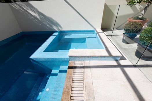 Almond Granite Paving & Almond Granite Grate & Sky Blue Pearl Fully Tiling stone tile or pool paver shown in situ with matching coping