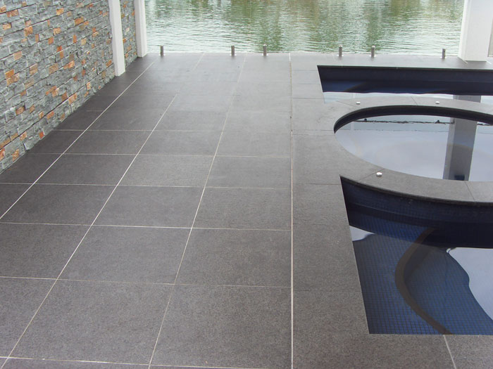 Black Granite stone tile or pool paver shown in situ with matching coping