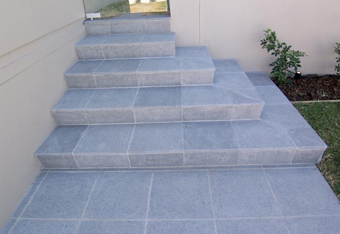 Dark Grey Granite Steps stone tile or pool paver shown in situ with matching step edge tiles