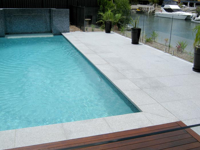 Light Grey Granite stone tile or pool paver shown in situ with matching coping