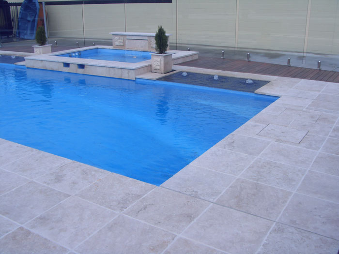 Travertine Linen stone tiles and coping around swimming pool and spa pool