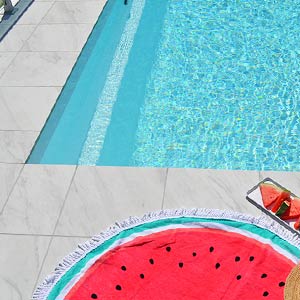 Carrara Marblano tiles shown around a pool