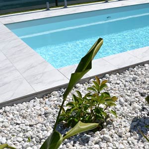 Carrara Marblano tiles shown around a pool