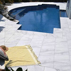 Carrara Marblano tiles shown around a pool