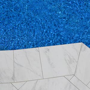Carrara Marblano tiles shown around a pool