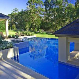 Nice exterior photo of a pool tiled with GC175 Sapphire Gold glass mosaic tiles