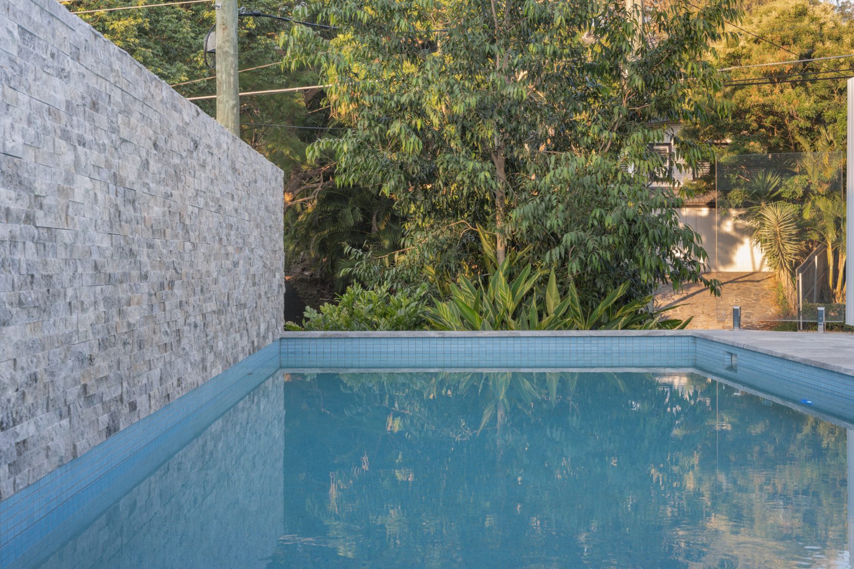 Silver Travertine walling, Silver Travertine coping and surrounds and Ice Blue waterline