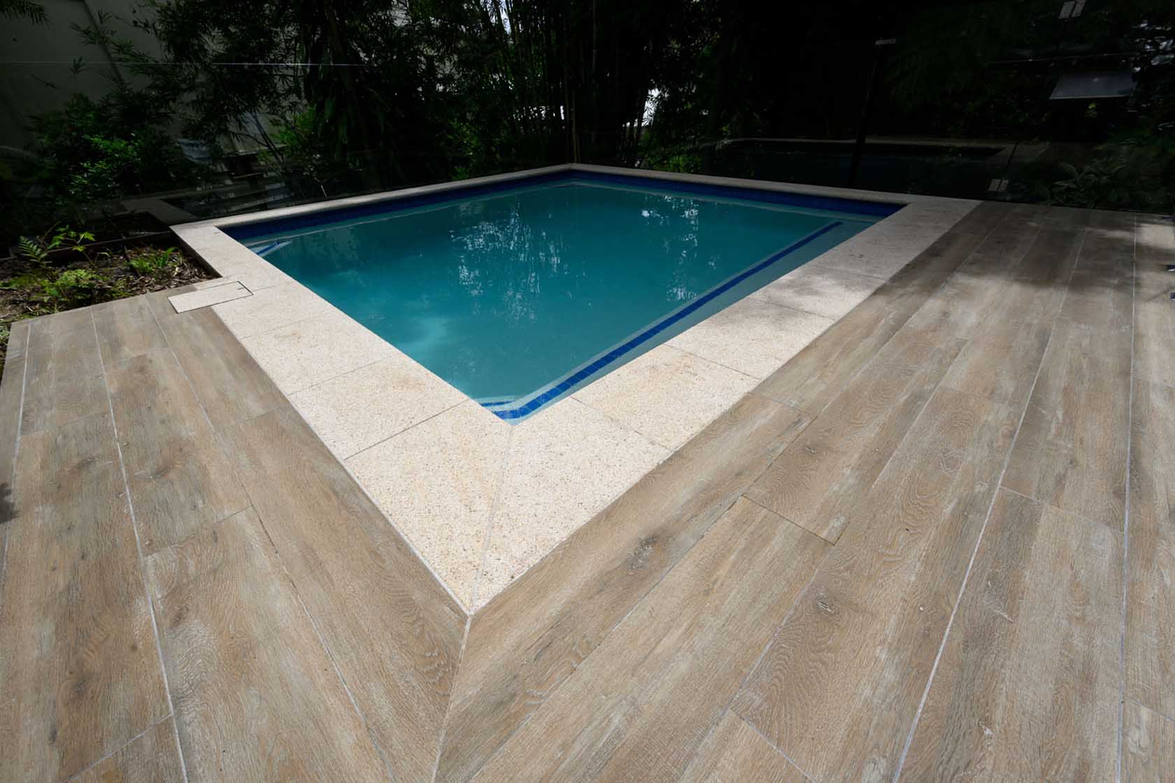 Oak TileDeck Timber-look surrounds with Almond Granite pool coping and CM148 Pacific Blue waterline tiles