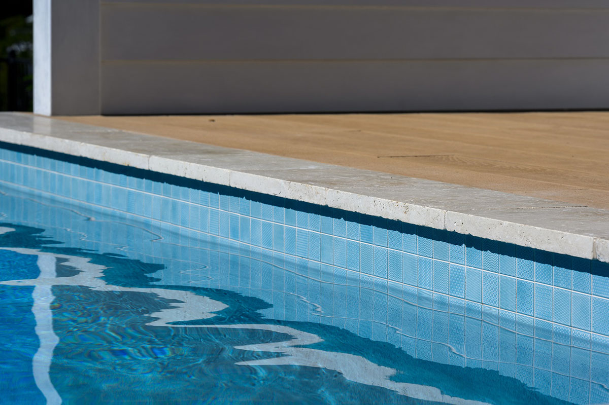 CMC430 Origami Ice Blue waterline tiles with Linen Travertine pool coping