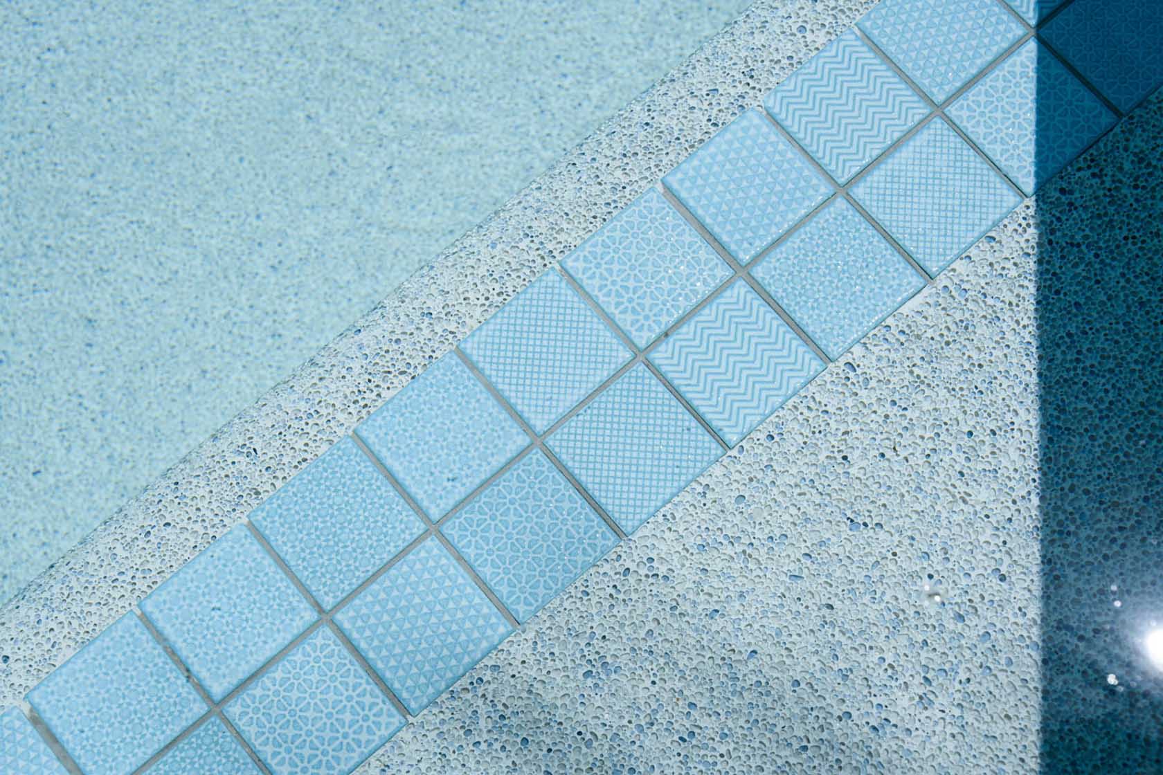 CMC430 Origami Ice Blue waterline and step marker tiles with Ash Marblano porcelain coping and surround tiles