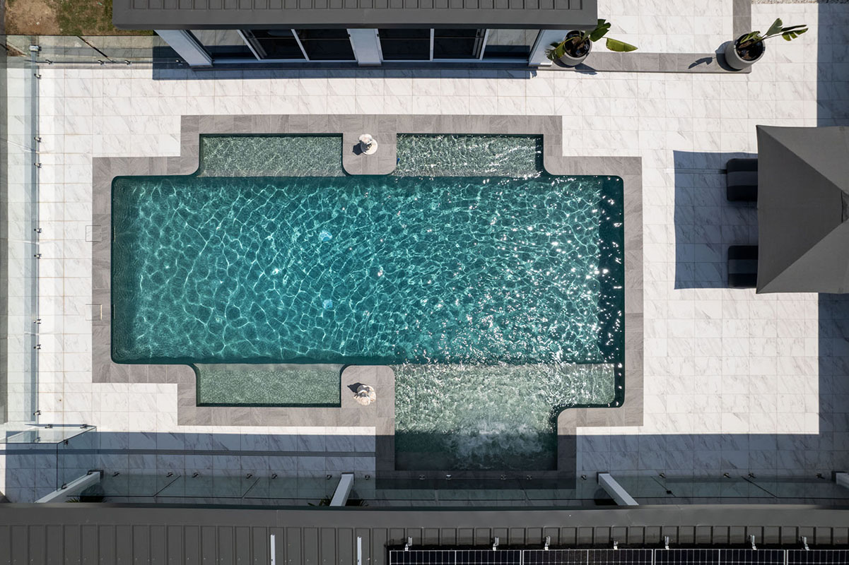 Fully-tiled large pool using CMC560 Ubud Green Wavy 23mm ceramic mosaic tile with Carrara Marblano porcelain pavers and Cosmos porcelain pool coping