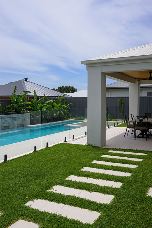 Coconut Drift Porcelain used as steppers for a pathway in the pool area to achieve a clean and sleek look.