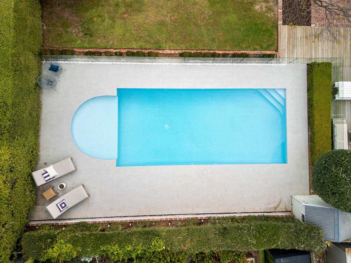 Eclipse Blustonio 20mm 14 Bird’s-eye view of a modern pool renovation in Mt Eliza, Victoria, featuring Eclipse Blustonio non-slip porcelain pavers with subtle veining and surrounding landscaping.
