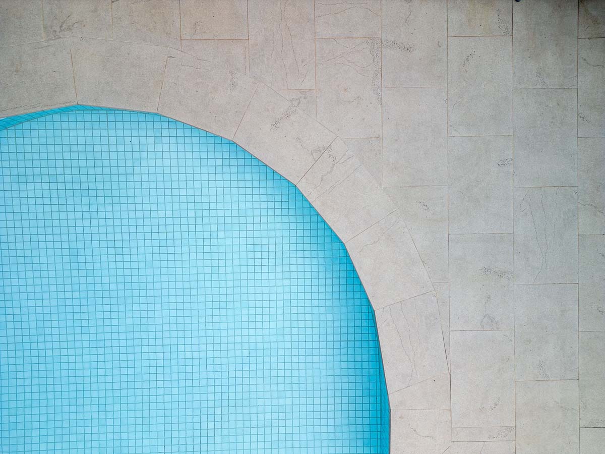 Eclipse Blustonio 20mm 7 Close-up overhead view of Eclipse Blustonio porcelain pool tile edge, highlighting its elegant contemporary design and subtle veining.