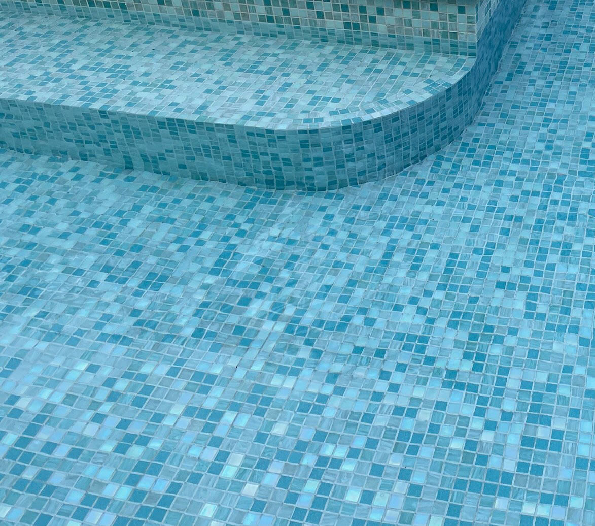 Luxury swimming pool with tiled waterline border, step and large wading shelf area all completed with GC472 Midori 20mm square glass mosaic tiles