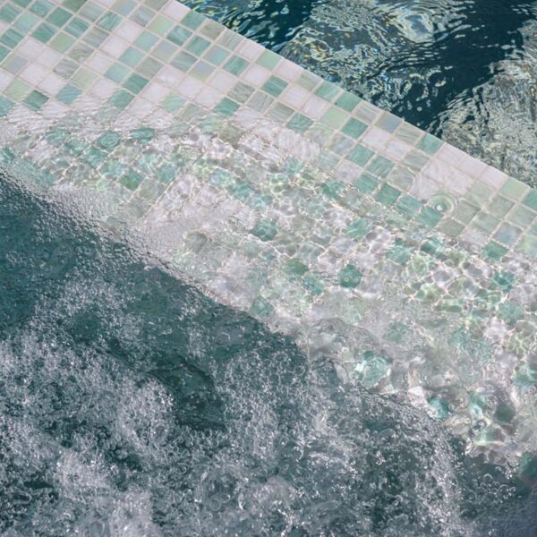 Close-up of Mojito GC475 glass mosaic tiles with bubble texture on a dam wall, adding playful texture and poolside visual interest by Pools By Design, Nambour Queensland.