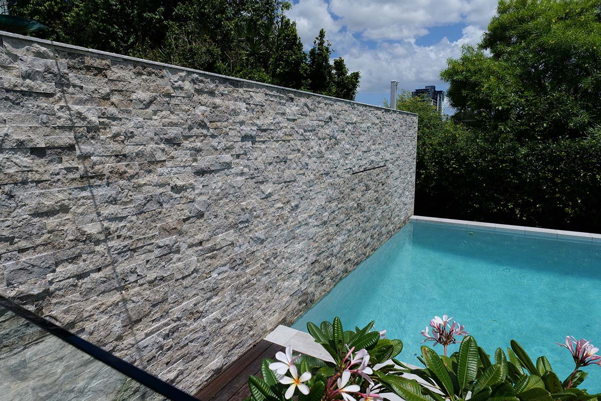 Ash Marblano Porcelain Dropface pool coping with Silver Travertine cladding on feature wall