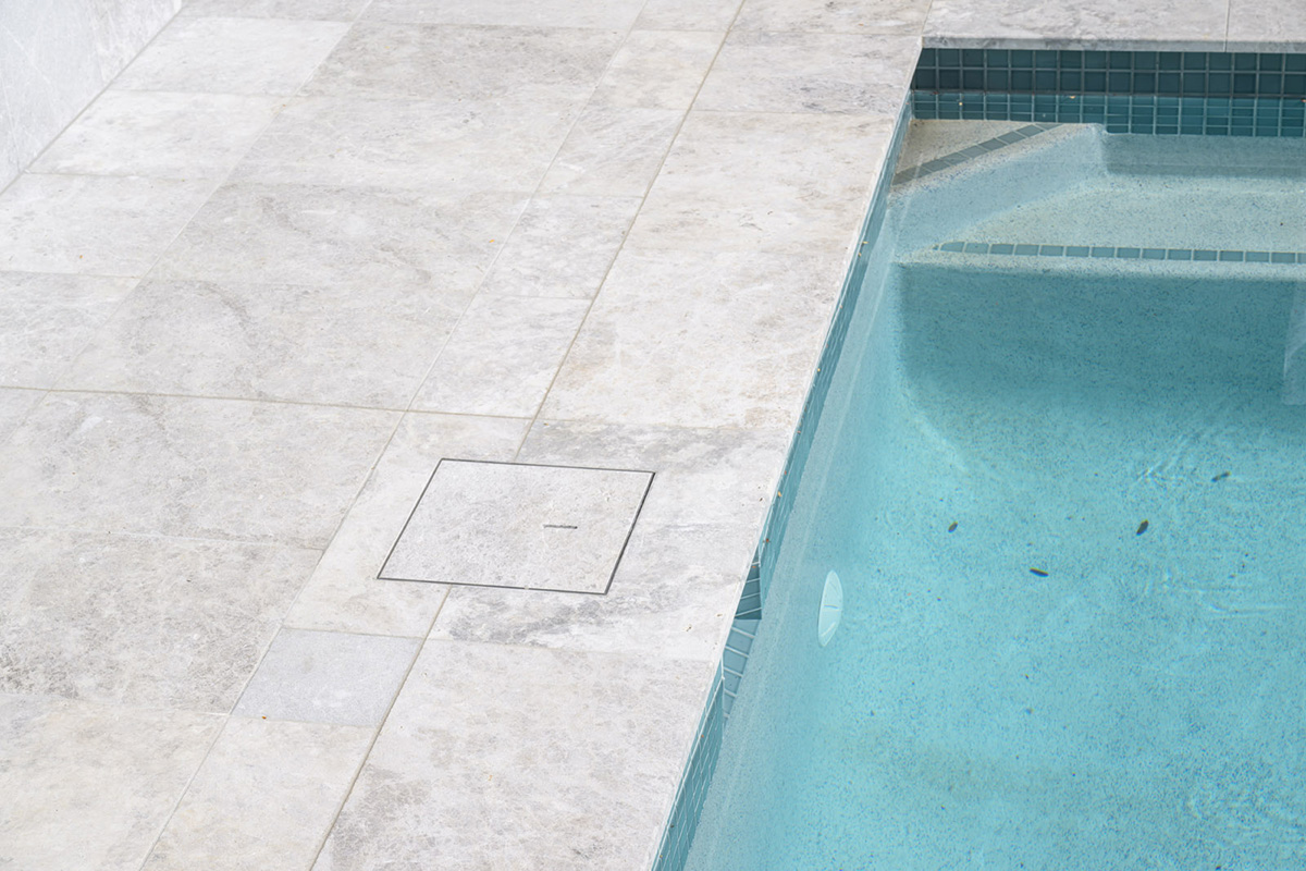 Arctic Dawn Marble Poolside tiling and coping with CMC 105 Peppercorn 48mm ceramic mosaic pool interior tiling