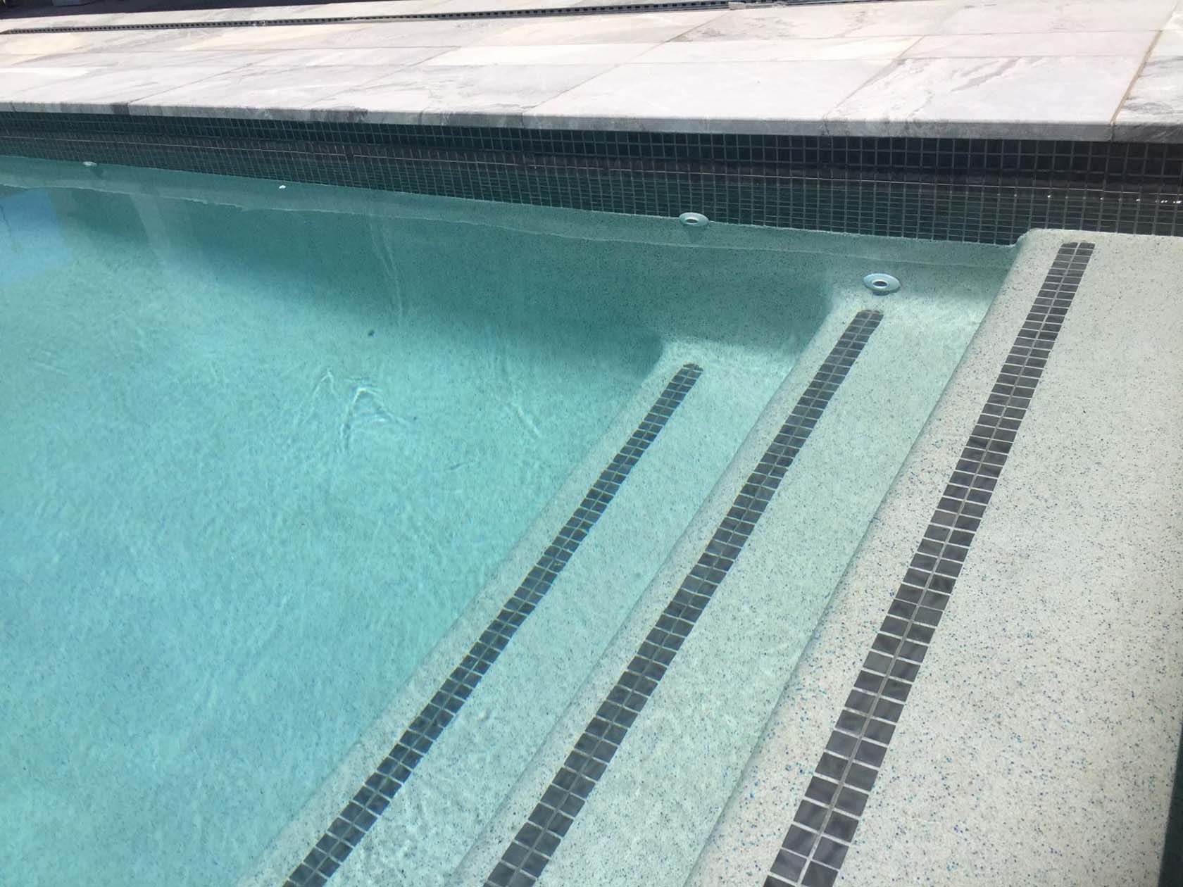 London Grey Marble pool coping  with CMC590 Graphite as waterline and step marker tiles