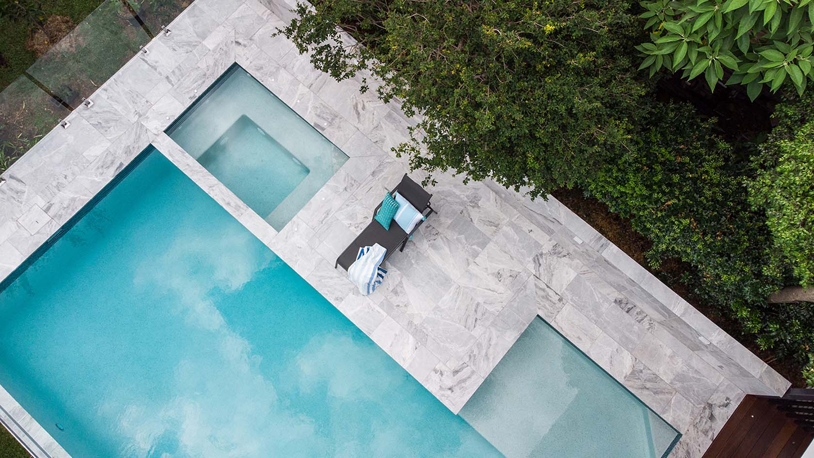 London Grey Marble pool coping and surround tiles with Peacock glass waterline