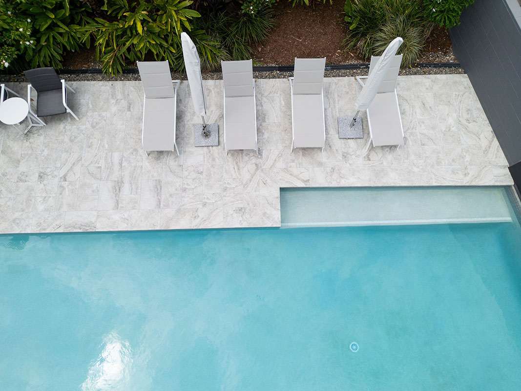 Rustic Grey Travertino pool coping and surrounds+ Carrara Wavy step marker