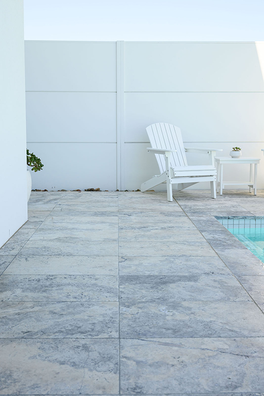 Silver Travertine for coping and surround tiles achieving a natural and organic feel in the pool area.