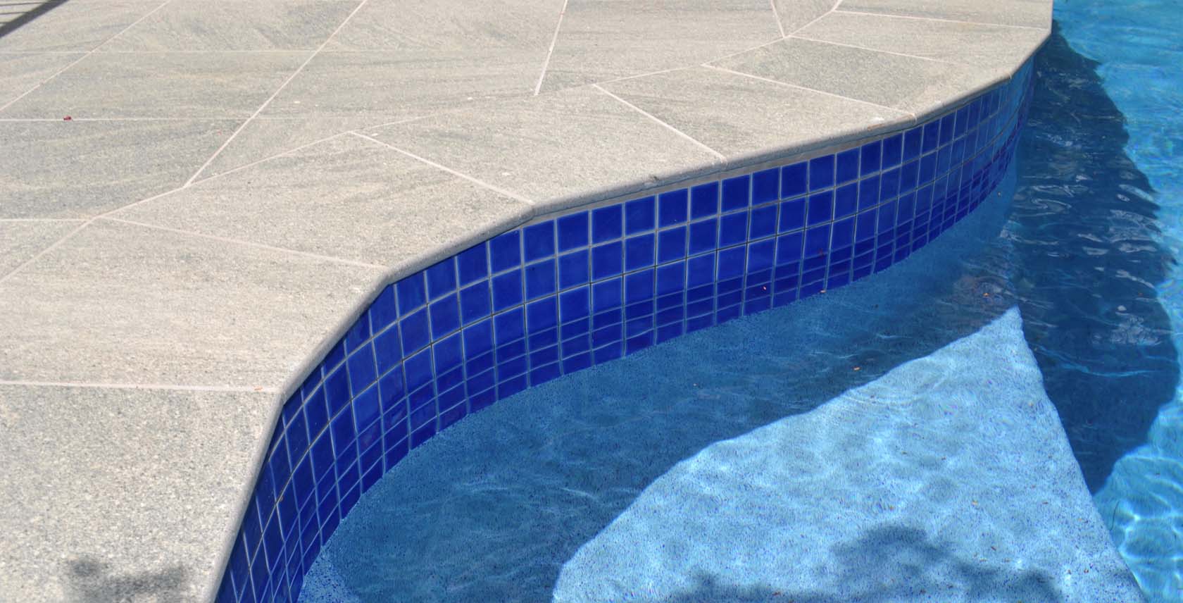 Cosmos Granito Porcelain Bullnose pool coping and surrounds with Coral Sea Waterline tiles
