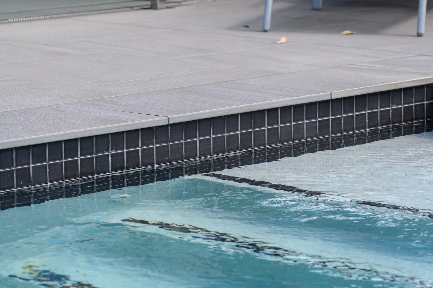 Jupiter Porcelain pool coping and surrounds with CMC305 Dark Grey ceramic waterline tiles