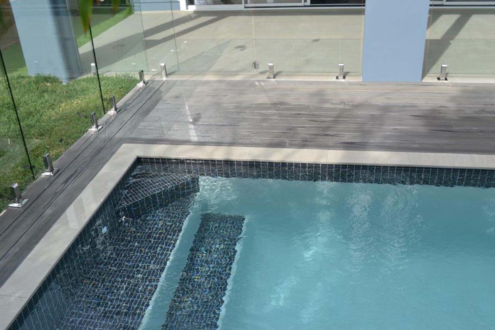 Mercury Porcealin pool coping with Dark Grey ceramic tile on waterline and steps