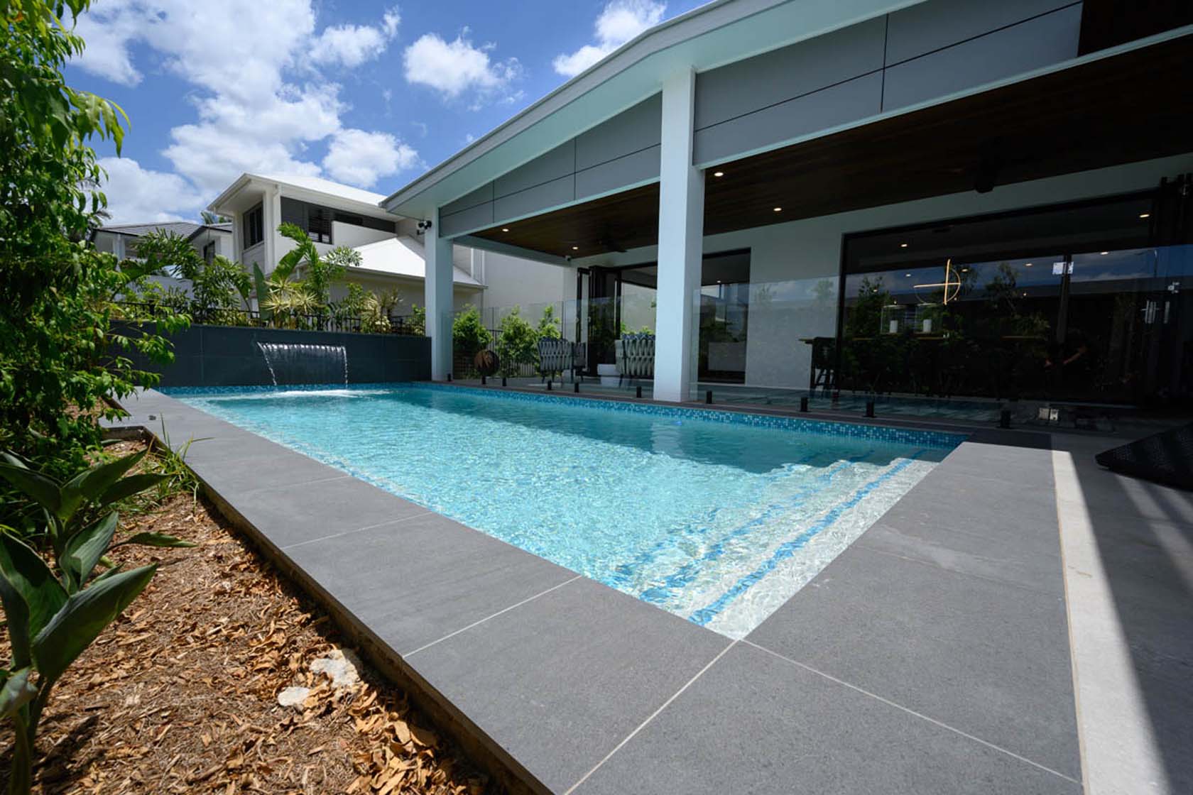 Venus Porcelain Bullnose pool coping with Amalfi Glass waterline and step marker tiles
