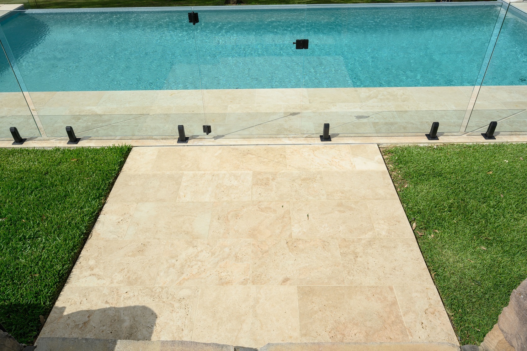 Linen Travertine pool coping and surrounds with Gunmetal Blue waterline tile