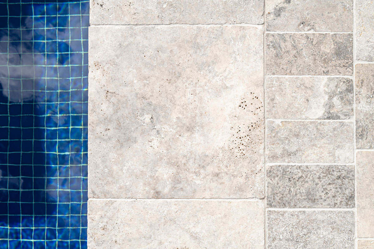 Silver Travertine pool coping with surrounds tiled in Silver Travertine cobbles