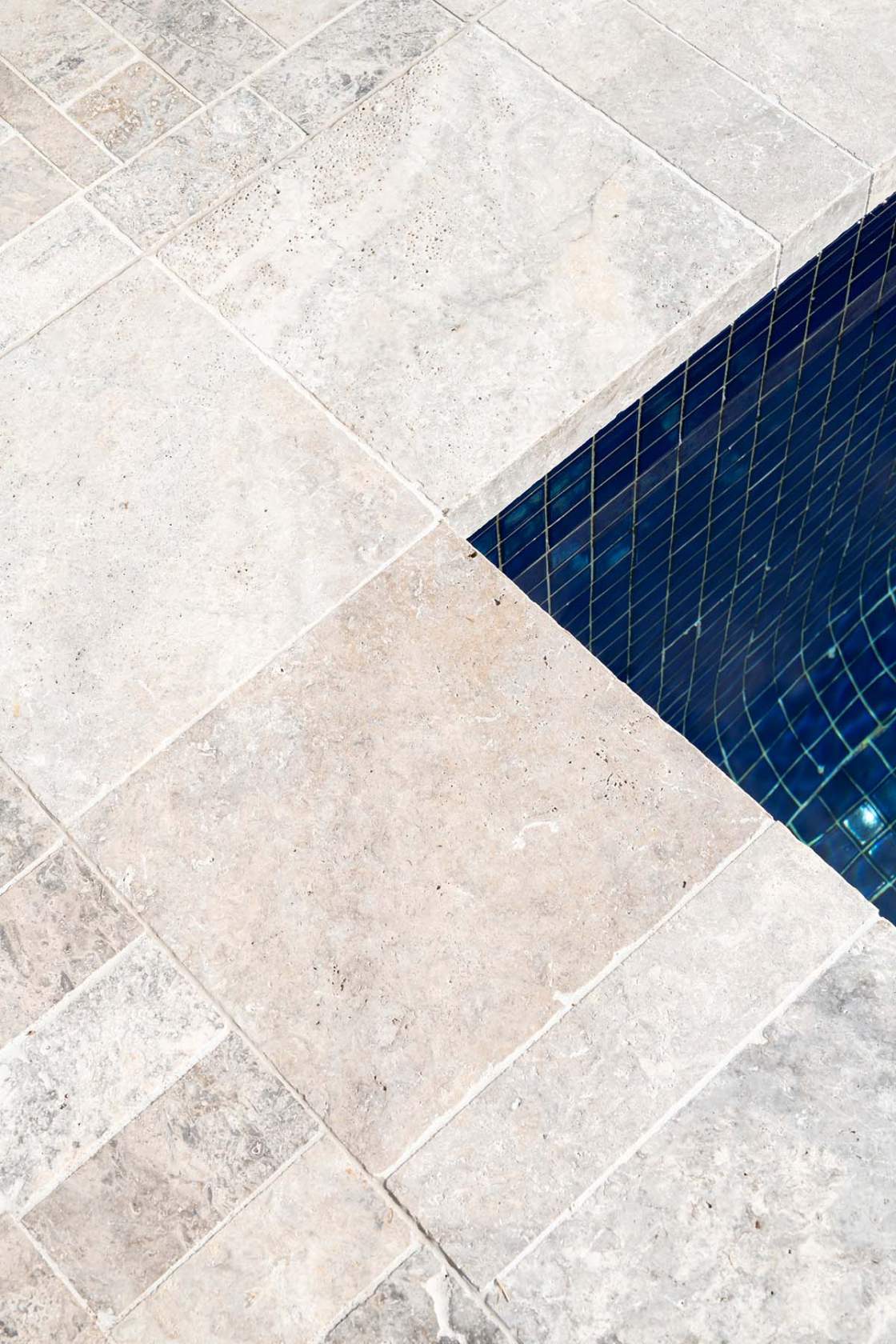 Silver Travertine pool coping with surrounds tiled in Silver Travertine cobbles